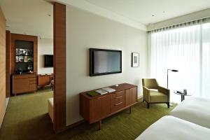a hotel room with a bed and a desk and a television at Eslite Hotel in Taipei