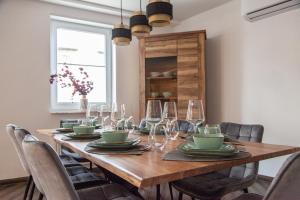 a dining room table with chairs and a large wooden table at nidusROOMS: Suite Hockenheim in Hockenheim