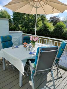 einen Tisch und Stühle mit einem Sonnenschirm auf einer Terrasse in der Unterkunft Haus Nr 42, Ferienhaus Fischerhus in Wangerland