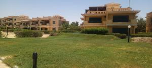 a large house with a green yard in front of it at Banana resort in Ras Sedr
