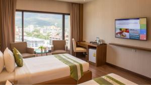 a hotel room with a bed and a desk and a television at Chiangmai Grandview Hotel & Convention Center - SHA Extra Plus in Chiang Mai