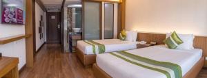 a hotel room with two beds and a bathroom at Chiangmai Grandview Hotel & Convention Center - SHA Extra Plus in Chiang Mai