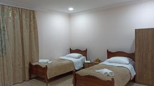 two twin beds in a room with white walls at Forest Guest House in Alaverdi