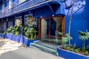 a blue building with a door and some plants at Hotel Kemps Corner in Mumbai