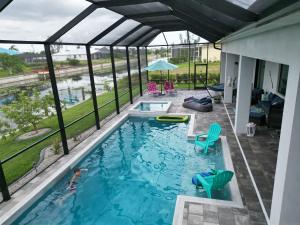 a swimming pool with a view of a house at Villa Mangifera with Salt Water Pool & Spa, EV-Loading in Cape Coral