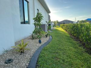 uma passarela ao lado de uma casa com algumas plantas em Villa Mangifera with Salt Water Pool & Spa, EV-Loading em Cape Coral