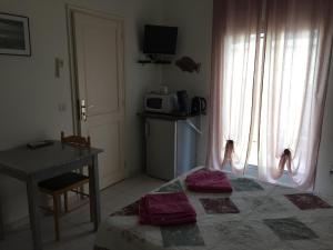 Schlafzimmer mit einem Bett, einem Tisch und einem Fenster in der Unterkunft Grande chambre dans villa proche de la plage in Sète