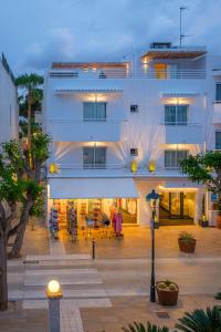 un edificio blanco con un patio delante en IROCO HOSTAL en Cala D'Or