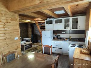 a kitchen with white appliances and a wooden ceiling at Vila Carobna suma Tara in Bajina Bašta