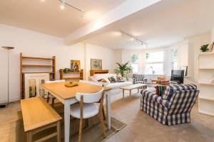 sala de estar con mesa y sofá en Spacious 2 bed Garden Flat by the Thames+parking, en Londres