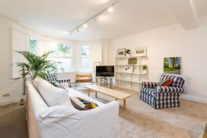 a living room with two white couches and a table at Spacious 2 bed Garden Flat by the Thames+parking in London