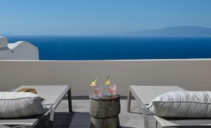 een tafel met twee drankjes op het balkon bij OIA UNIQUE HOMES by K&K in Oia