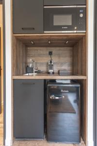 eine kleine Küche mit einer Spüle und einer Mikrowelle in der Unterkunft La villa MaRisKa et son SPA in Ouistreham