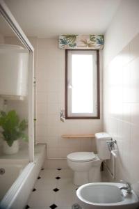 La salle de bains est pourvue de toilettes, d'une fenêtre et d'un lavabo. dans l'établissement Casa amplia, confortable, céntrica by Prishomes, à Vigo