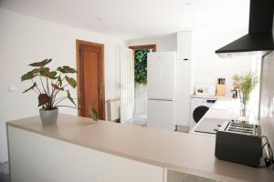una cucina con bancone bianco e frigorifero bianco di Casa amplia, confortable, céntrica by Prishomes a Vigo