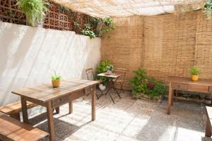 un patio con tavoli, sedie e un muro di mattoni di Casa amplia, confortable, céntrica by Prishomes a Vigo