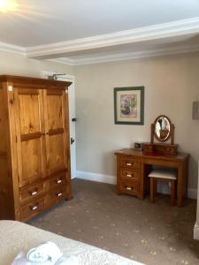 sypialnia z łóżkiem, komodą i lustrem w obiekcie Barons Court w mieście Great Yarmouth