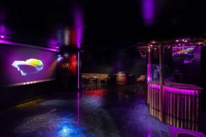 a room with purple lights and a table and chairs at PikBeach77 in Saint-Fargeau-Ponthierry