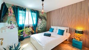 1 dormitorio con cama blanca y almohadas azules en PikBeach77, en Saint-Fargeau-Ponthierry