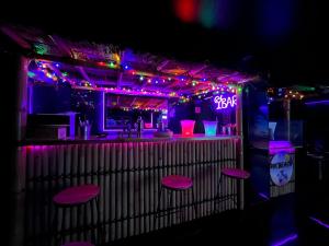 a bar with purple lights and a bar with stools at PikBeach77 in Saint-Fargeau-Ponthierry +11 photos