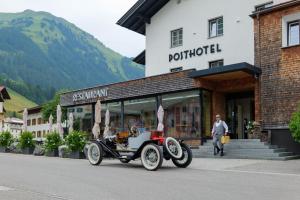 une vieille voiture garée devant un bâtiment dans l'établissement Posthotel Lechtal, à Holzgau