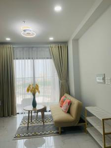 a living room with a chair and a table and a window at Charm Plaza Aparment in Dĩ An