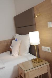 Schlafzimmer mit einem Bett und einem Tisch mit einer Lampe in der Unterkunft Best Western Hotel Der Föhrenhof in Hannover