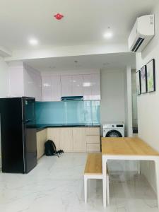 a kitchen with a black refrigerator and a table at Charm Plaza Aparment in Dĩ An