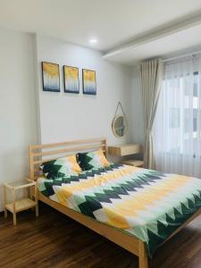 a bedroom with a large bed with a colorful comforter at Charm Plaza Aparment in Dĩ An