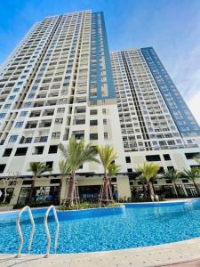 a large building with a swimming pool in front of it at Charm Plaza Aparment in Dĩ An