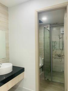 a bathroom with a glass shower and a sink at Charm Plaza Aparment in Dĩ An