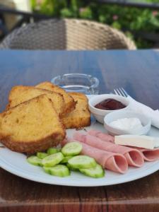 a plate of food with meats and bread on a table at Bački dvor 