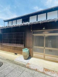 a building with a gate and a vase in front of it at えん飛鳥　日本始まりの地　古民家一棟貸し　8人＋大型犬も宿泊可能 in Asuka