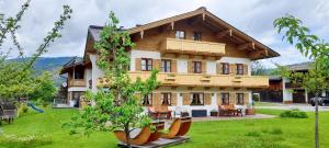 a large wooden house with a green yard at Knapphof in Reit im Winkl