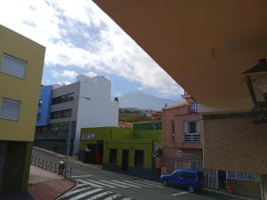 widok na ulicę miejską z budynkami i niebieskim samochodem w obiekcie Loft Estudio Habitación independiente w mieście Icod de los Vinos