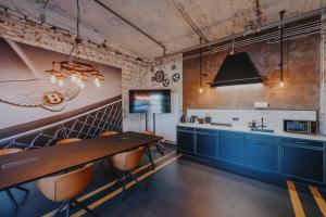 a kitchen with blue cabinets and a dining table at V8 Hotel Köln at MOTORWORLD in Cologne