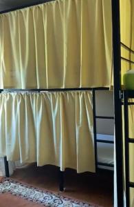 a bunk bed with a yellow curtain in a room at Travelers House in Setúbal