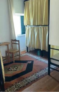 een kamer met een bed, een stoel en een raam bij Travelers House in Setúbal