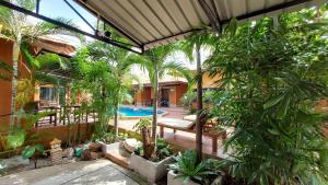 an indoor garden with a swimming pool and trees at Panisara Pool Villa Resort Huahin in Hua Hin