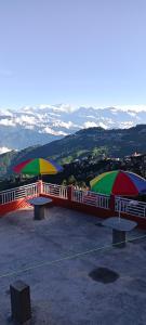 two benches with umbrellas on top of a building at Rambler's Nesting Homestay in Darjeeling
