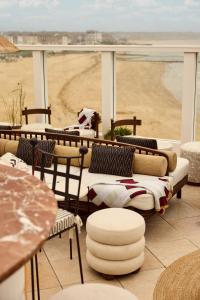 a balcony with couches and tables and a view of a beach at No 42 by GuestHouse, Margate in Margate