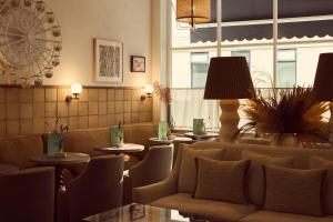 a hotel lobby with a couch and tables and windows at No 42 by GuestHouse, Margate in Margate