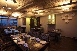 班加羅爾的住宿－juSTa MG Road，一间在房间内配有长桌子和椅子的餐厅
