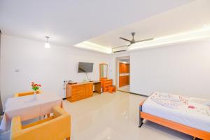 uma sala de estar com duas camas e uma televisão em Oasis Riverside Hotel em Kalutara