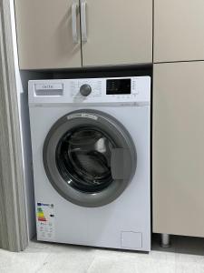 uma máquina de lavar roupa branca ao lado de um armário branco em Cozy Apartment em Rădăuţi