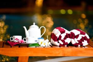 uma mesa com 2 toalhas de malha e uma chaleira para chá em Oasis Riverside Hotel em Kalutara