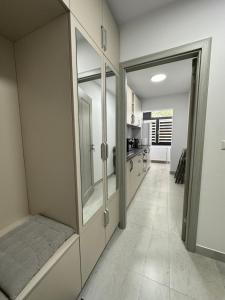 a bathroom with glass doors and a hallway with a kitchen at Cozy Apartment in Rădăuţi