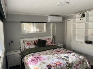 1 dormitorio con 1 cama con colcha de flores en BBs B&B, en Lower Hutt