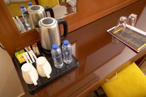 a counter with a drink dispenser and bottles of water at Rose Jeddah Hotel in Jeddah