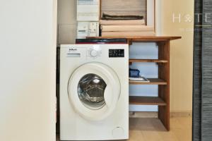 eine Waschmaschine in einem Zimmer mit Regal in der Unterkunft L'Airial - Maison idéalement située entre commerces et plage in Olonne-sur-Mer
